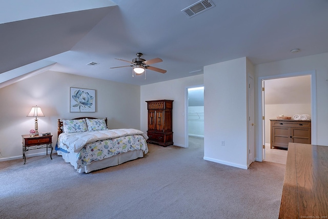 bedroom featuring light carpet, a walk in closet, vaulted ceiling, ceiling fan, and a closet