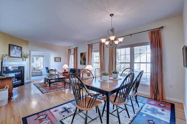 dining space with plenty of natural light, a chandelier, and light wood-type flooring