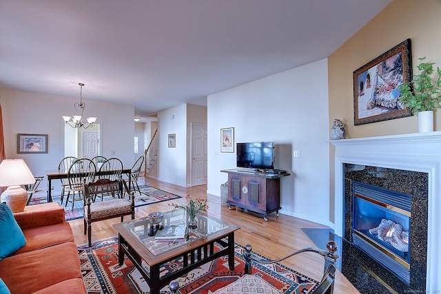 living room featuring a fireplace, hardwood / wood-style floors, and a notable chandelier