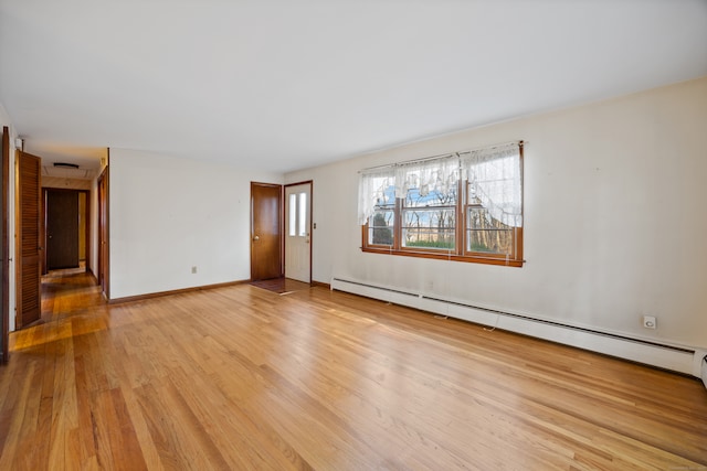 spare room featuring light wood-type flooring and a baseboard heating unit