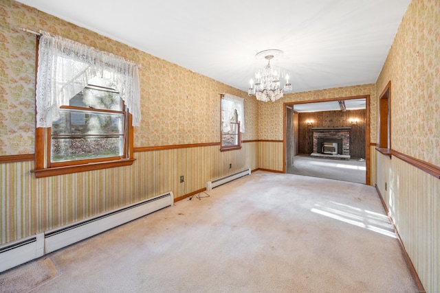 carpeted spare room featuring a baseboard radiator, a notable chandelier, and plenty of natural light