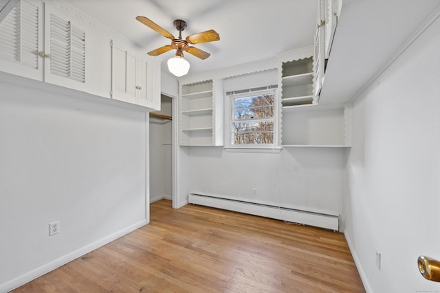 walk in closet with baseboard heating, light wood-type flooring, and ceiling fan