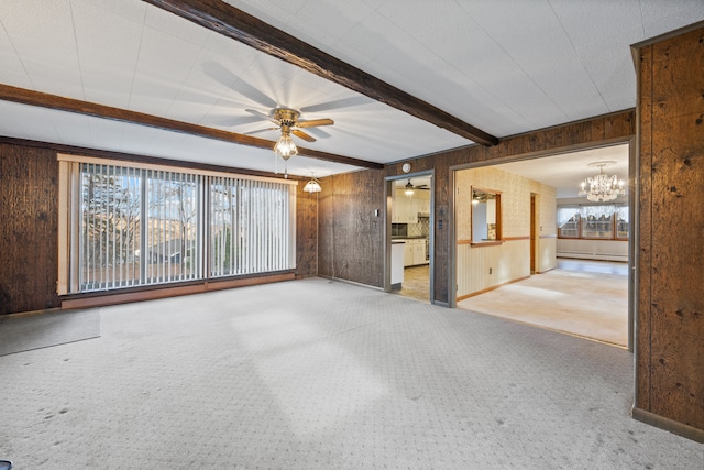 unfurnished room with carpet, a wealth of natural light, wooden walls, and beam ceiling