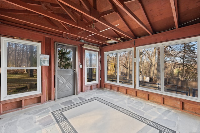 unfurnished sunroom featuring vaulted ceiling