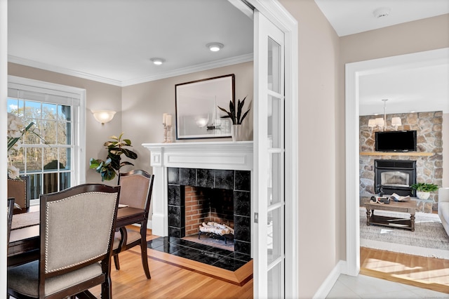 interior space featuring a stone fireplace, light hardwood / wood-style flooring, and ornamental molding