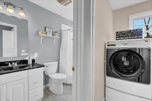 bathroom featuring vanity, tile patterned floors, toilet, curtained shower, and washer / dryer