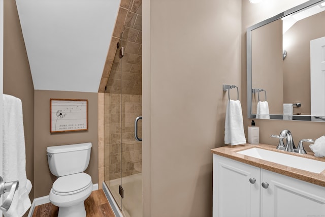 bathroom featuring an enclosed shower, vanity, vaulted ceiling, wood-type flooring, and toilet