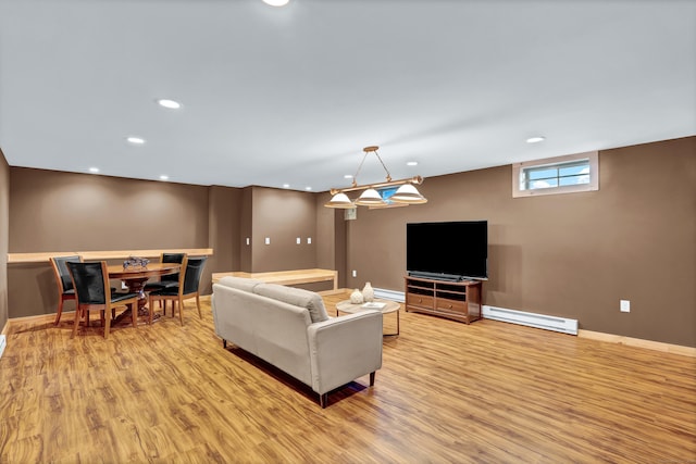 living room with baseboard heating and light hardwood / wood-style flooring