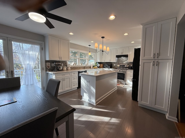 kitchen featuring hanging light fixtures, white cabinetry, black appliances, and dark hardwood / wood-style flooring