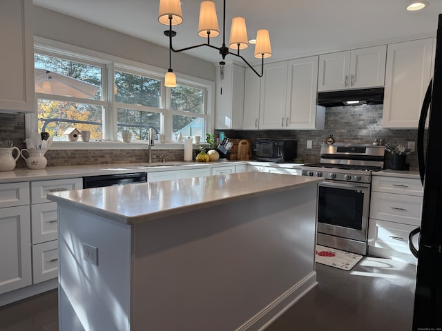 kitchen featuring appliances with stainless steel finishes, an inviting chandelier, hanging light fixtures, a kitchen island, and white cabinets