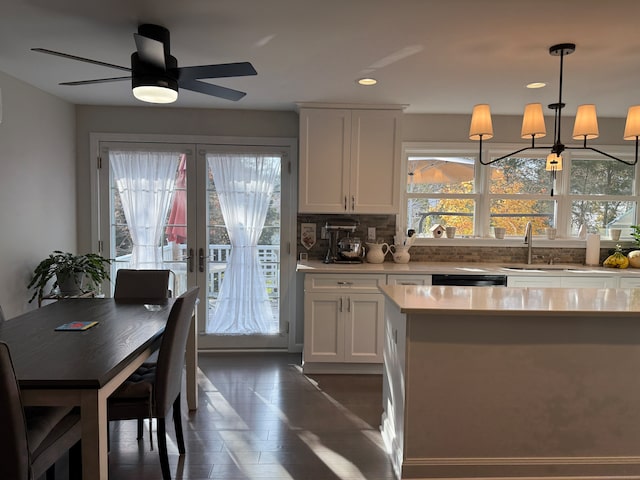 kitchen featuring french doors, white cabinets, decorative backsplash, sink, and decorative light fixtures