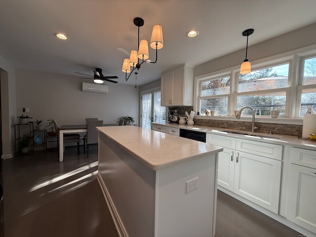 kitchen featuring a center island, hanging light fixtures, sink, dark hardwood / wood-style floors, and white cabinetry