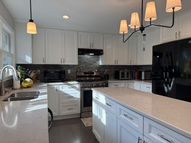 kitchen featuring black appliances, white cabinetry, hanging light fixtures, decorative backsplash, and sink