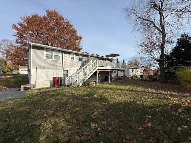 back of property with a lawn and a wooden deck