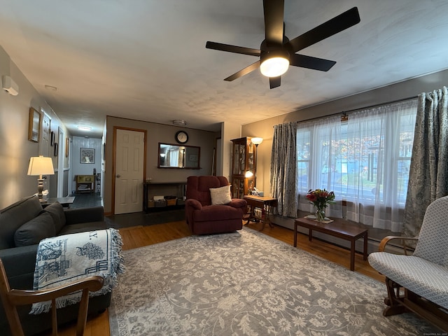 living room featuring wood-type flooring and ceiling fan