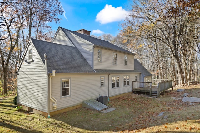 back of house featuring central AC, a lawn, and a deck