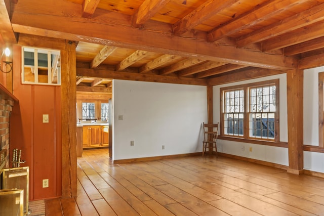 unfurnished living room featuring light wood-type flooring, wood ceiling, and beam ceiling