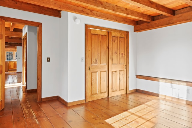 empty room with hardwood / wood-style floors, beam ceiling, and wood ceiling