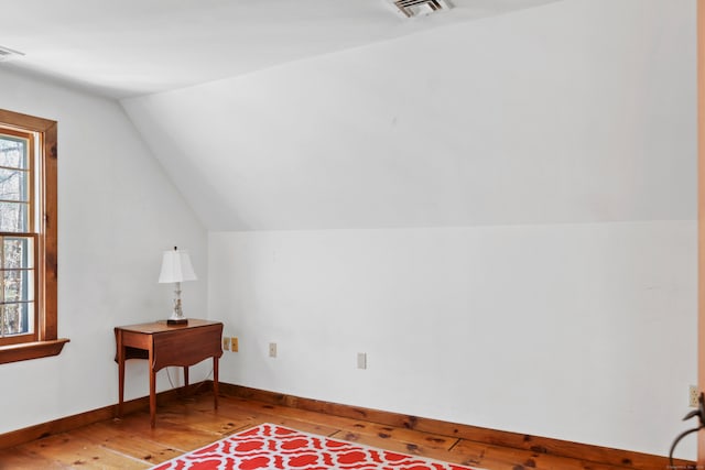 additional living space featuring lofted ceiling and hardwood / wood-style floors