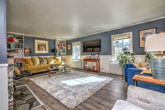 living room featuring built in features, dark hardwood / wood-style floors, and radiator heating unit