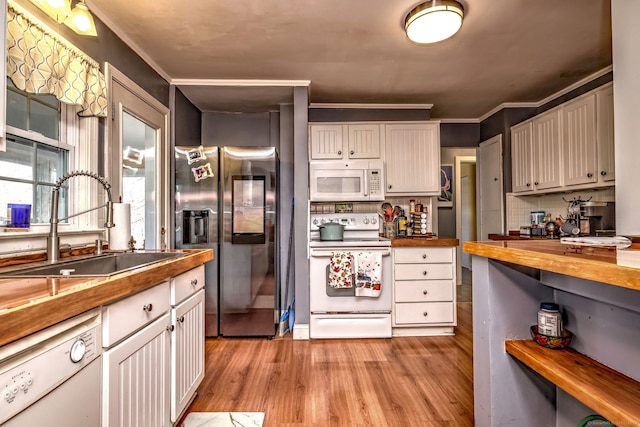 kitchen featuring ornamental molding, light wood-type flooring, butcher block countertops, and white appliances