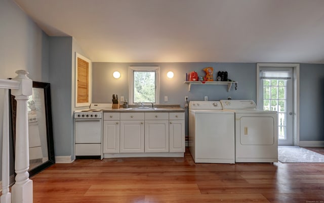 laundry area with light hardwood / wood-style flooring, sink, independent washer and dryer, and plenty of natural light