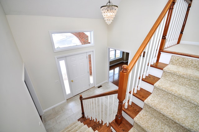 entrance foyer featuring a high ceiling, light wood-type flooring, and an inviting chandelier