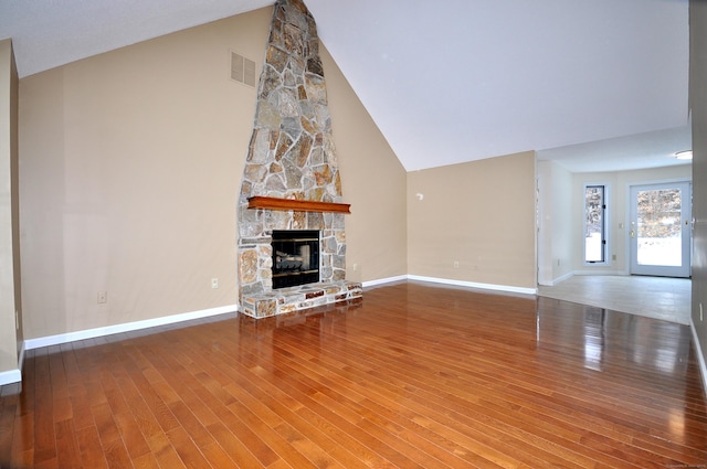 unfurnished living room featuring wood-type flooring, a fireplace, and high vaulted ceiling