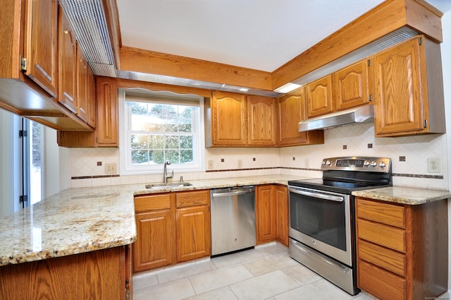 kitchen featuring stainless steel appliances, light stone countertops, sink, and light tile patterned floors