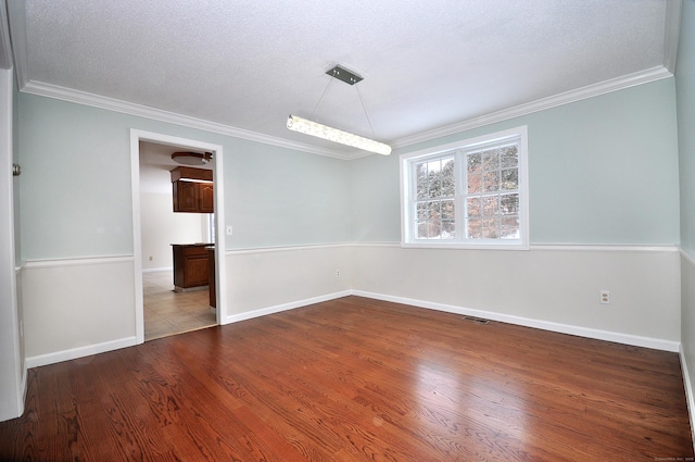 spare room featuring crown molding, light hardwood / wood-style floors, and a textured ceiling