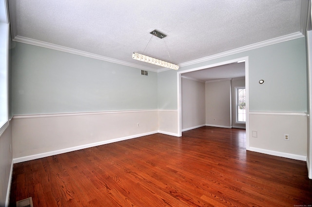 spare room with ornamental molding, dark wood-type flooring, and a textured ceiling