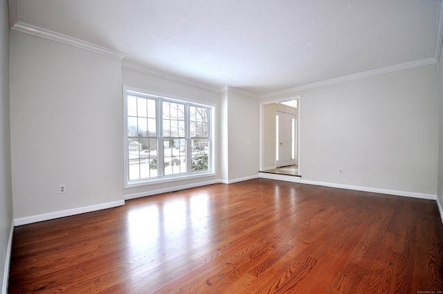 spare room with ornamental molding and dark hardwood / wood-style floors