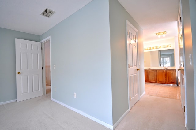 hallway featuring light carpet