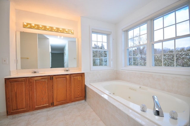 bathroom featuring a relaxing tiled tub, vanity, and tile patterned flooring