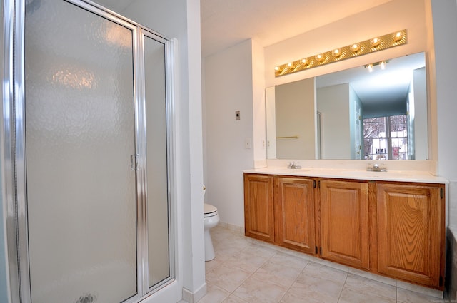 bathroom with tile patterned flooring, toilet, vanity, and walk in shower