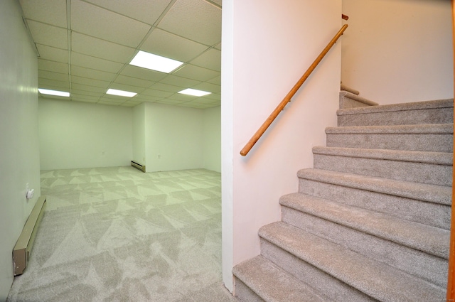 stairs featuring a baseboard radiator, a paneled ceiling, and carpet flooring