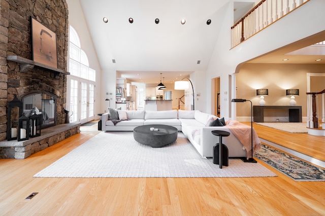 living room featuring hardwood / wood-style floors, a fireplace, and high vaulted ceiling