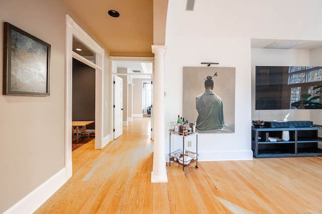 hallway with hardwood / wood-style flooring and ornate columns