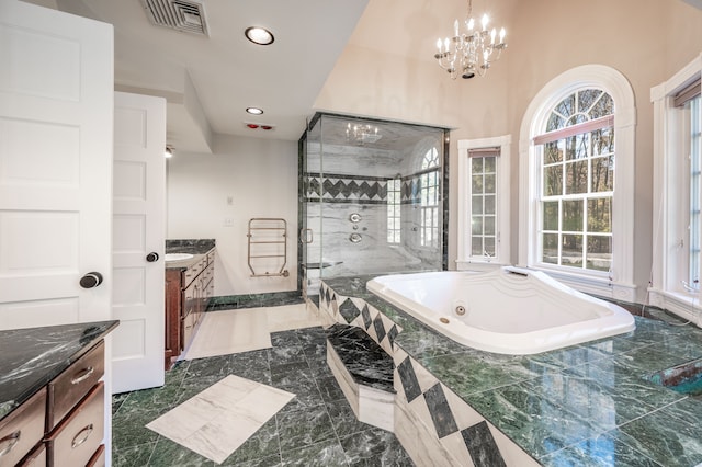 bathroom featuring a chandelier, vanity, and separate shower and tub