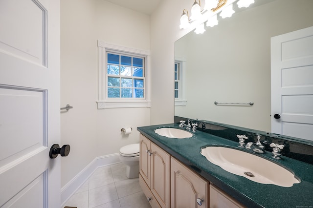 bathroom with toilet, vanity, and tile patterned flooring