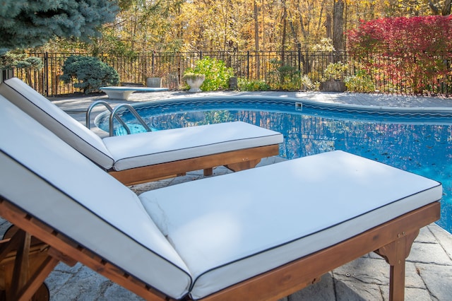 view of swimming pool with a hot tub