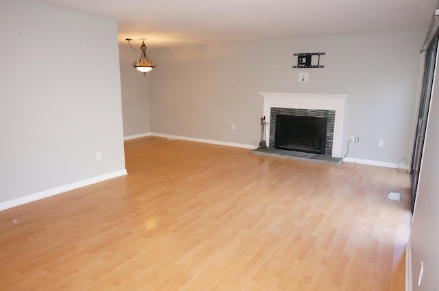 unfurnished living room with a fireplace and light hardwood / wood-style floors