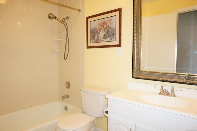 full bathroom featuring tiled shower / bath, vanity, and toilet