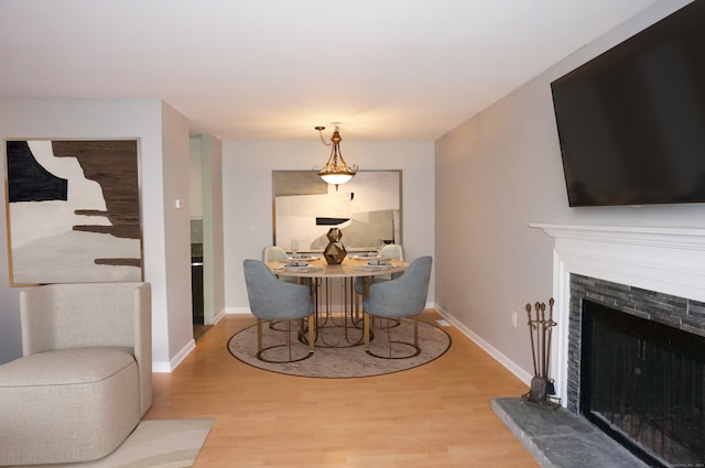 dining room with a fireplace and light wood-type flooring