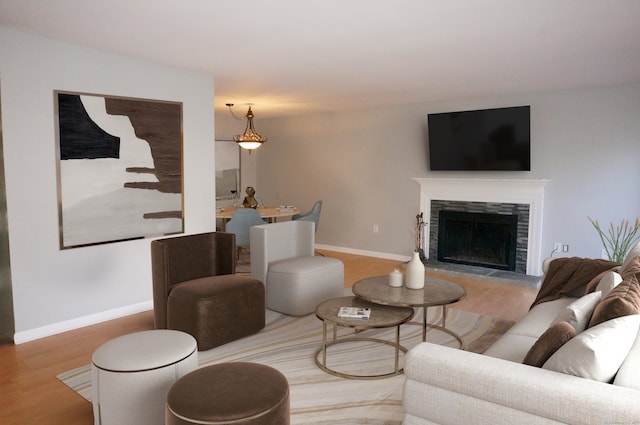 living room featuring hardwood / wood-style floors and a stone fireplace