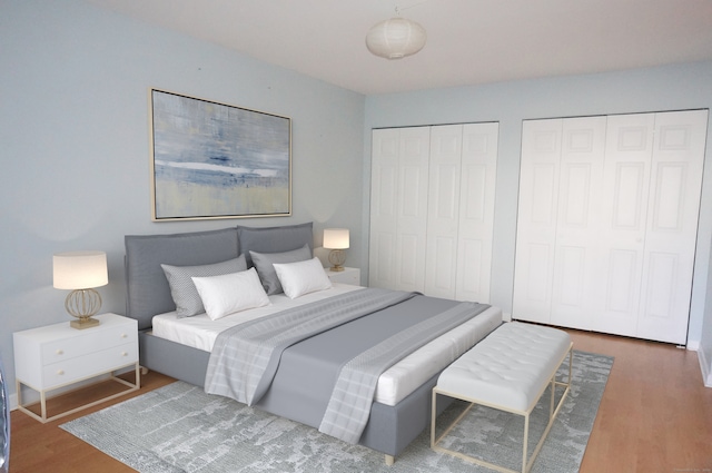 bedroom featuring two closets and dark wood-type flooring