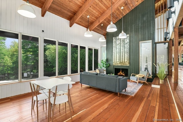 sunroom / solarium with vaulted ceiling with beams, a fireplace, and wood ceiling