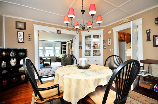 dining room with a notable chandelier, dark hardwood / wood-style floors, and crown molding