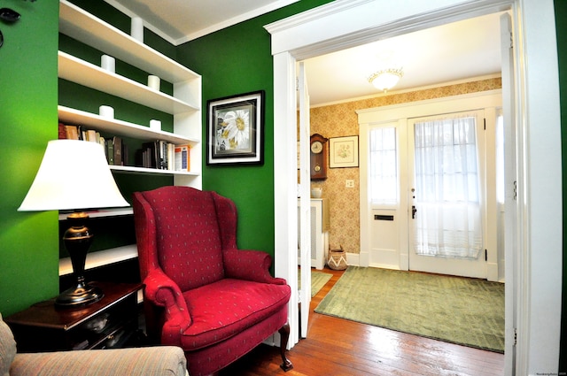 sitting room with hardwood / wood-style flooring and crown molding