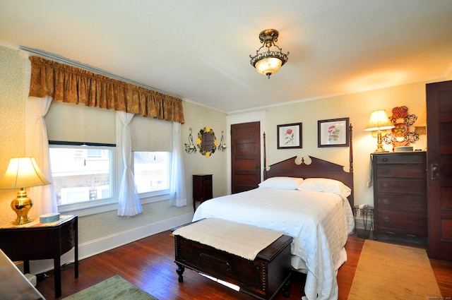 bedroom with ornamental molding and dark hardwood / wood-style flooring